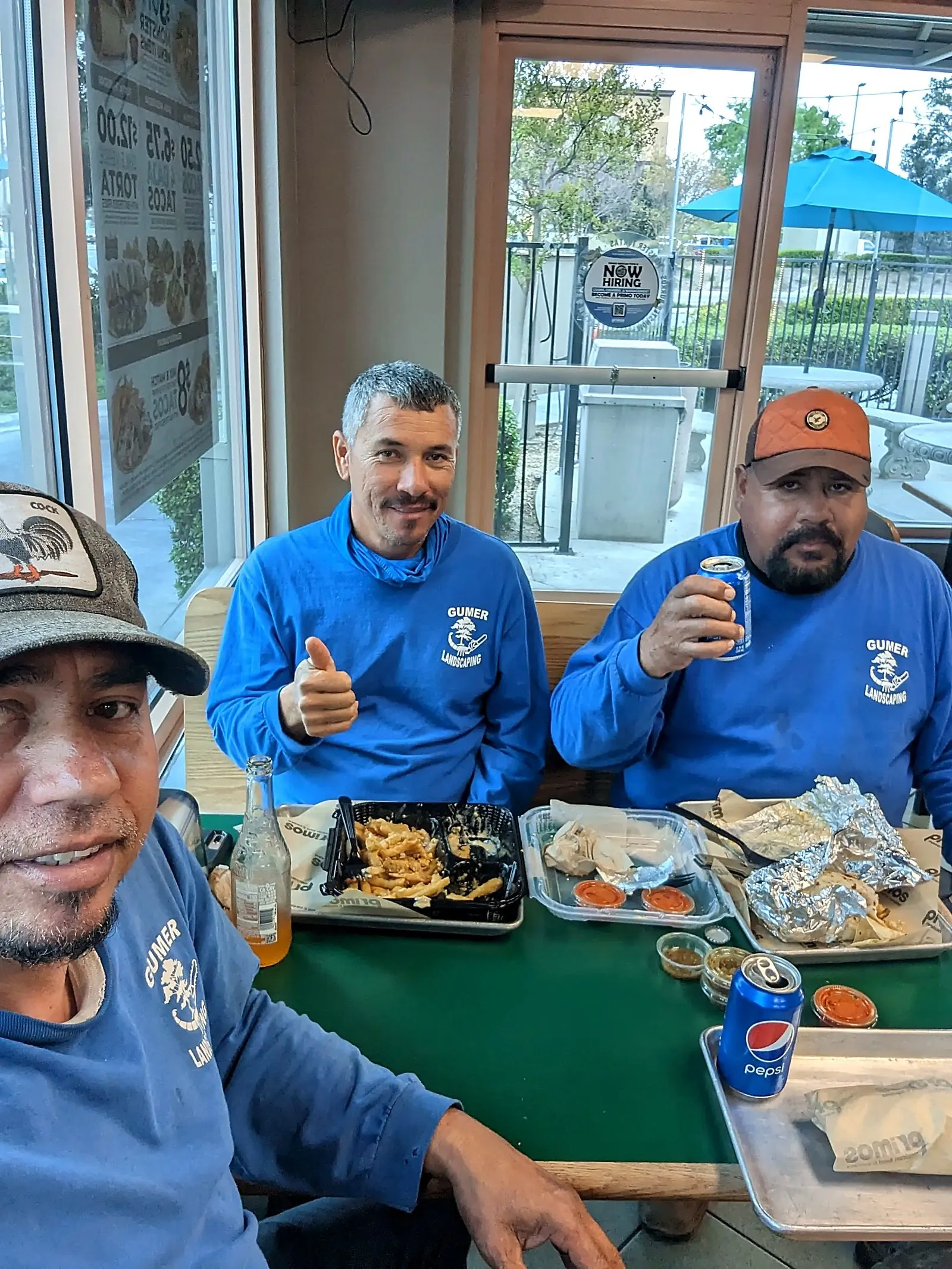 Three Creation Landscapes crew members in matching blue work shirts taking a lunch break together